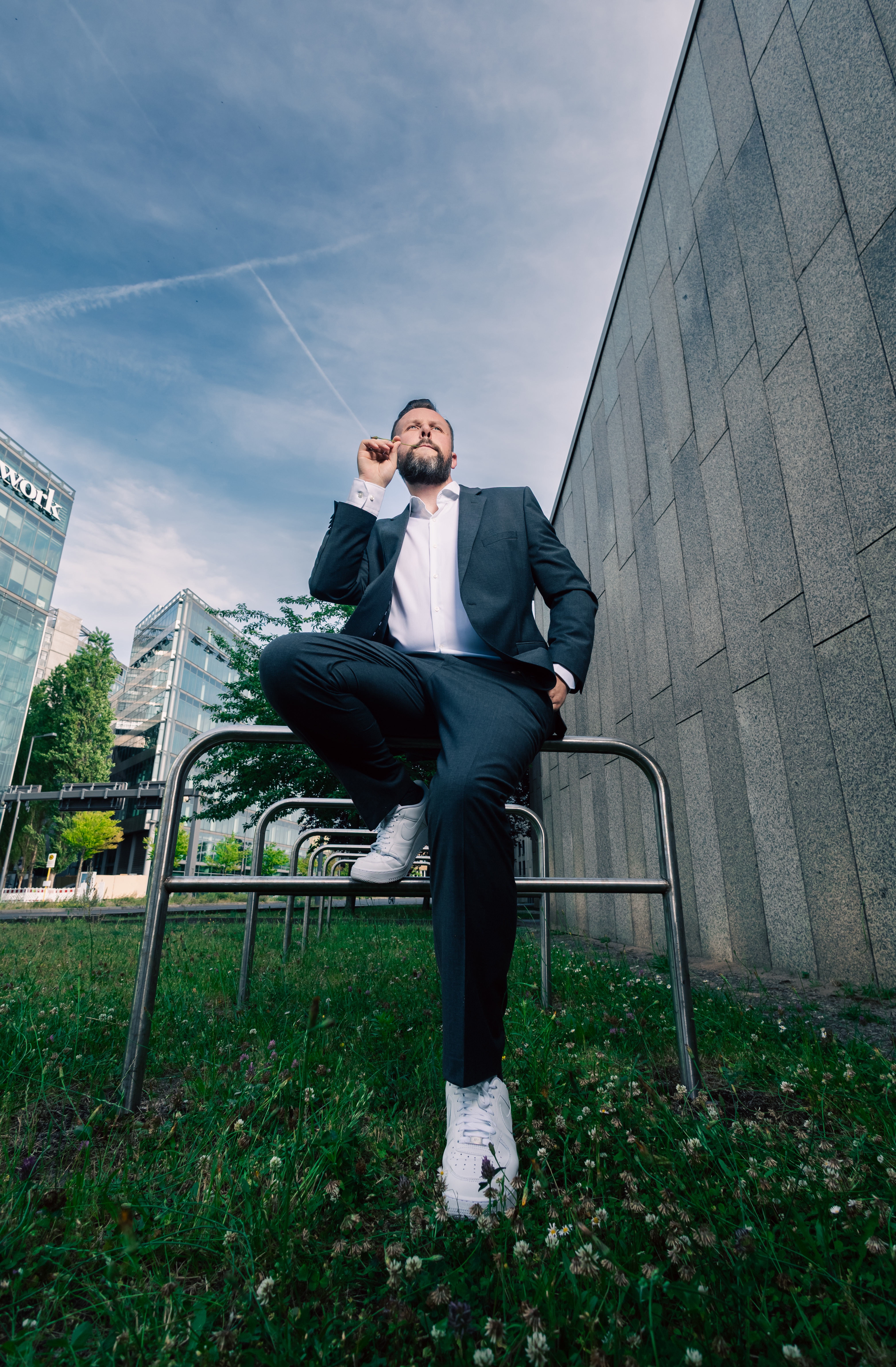 Simon Bode im Anzug vor urbaner Architektur